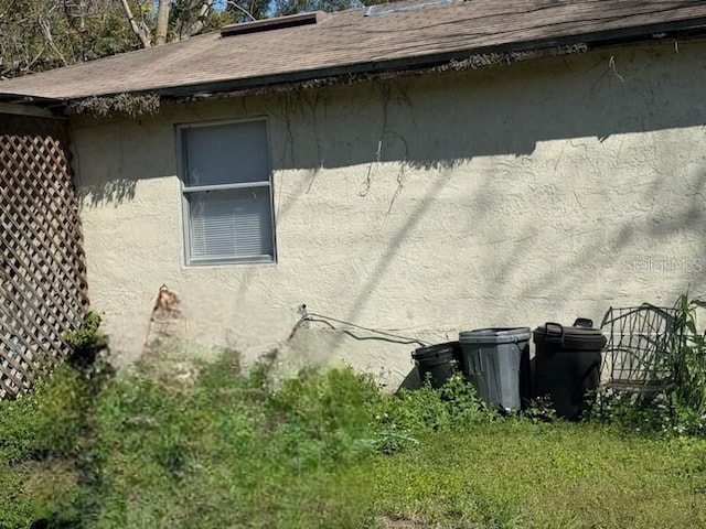 view of home's exterior featuring roof with shingles and stucco siding