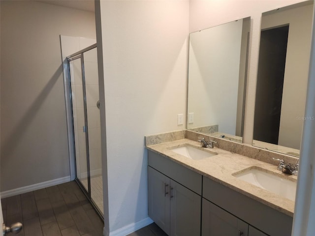 bathroom featuring hardwood / wood-style floors, vanity, and a shower with door