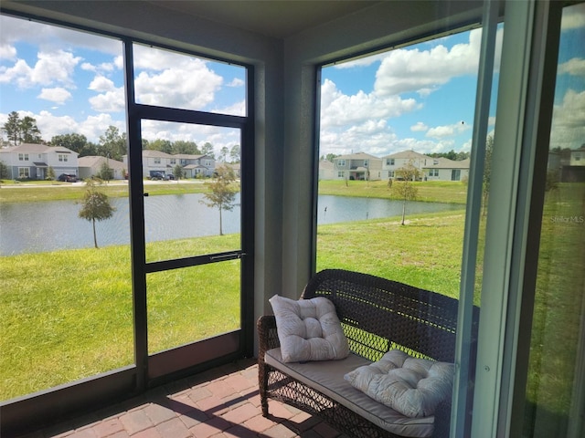 sunroom featuring a water view