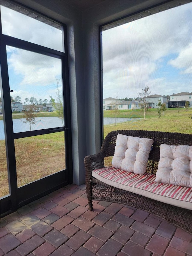 sunroom featuring a water view