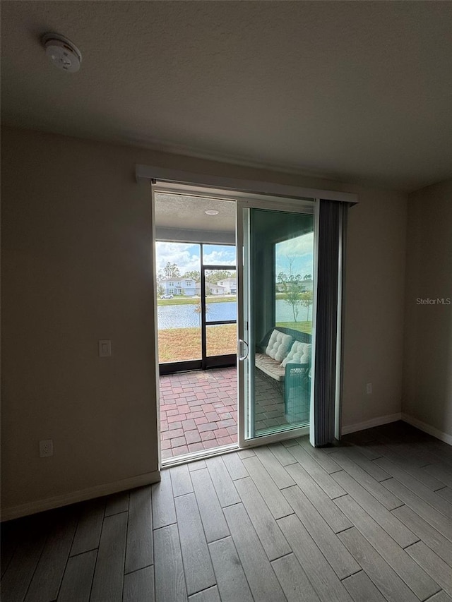 empty room featuring a water view and light hardwood / wood-style flooring