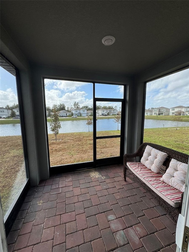 unfurnished sunroom featuring a water view