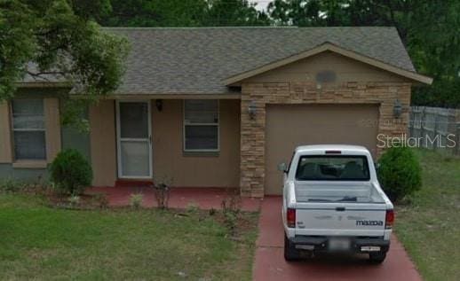 ranch-style home with a front yard and a garage