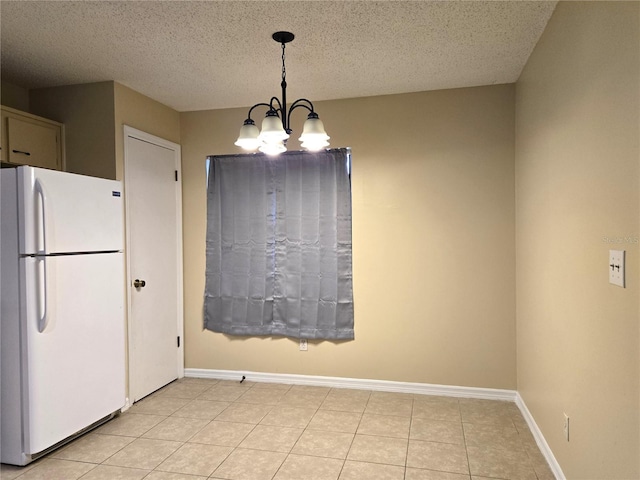 unfurnished dining area with light tile patterned floors, a chandelier, and a textured ceiling