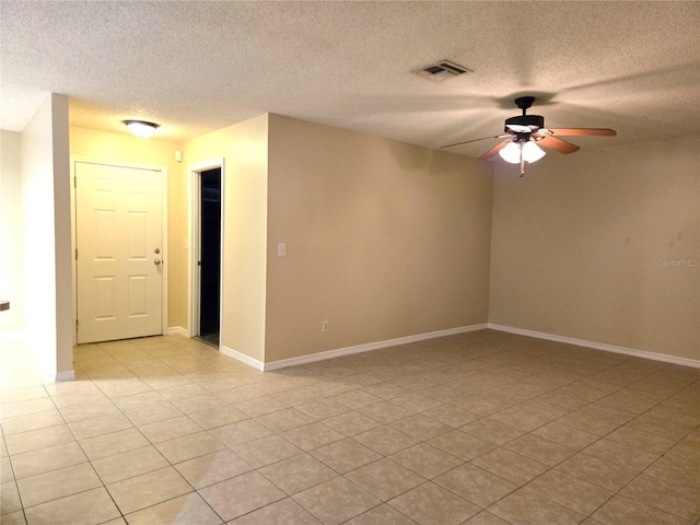 spare room featuring light tile patterned floors, a textured ceiling, and ceiling fan