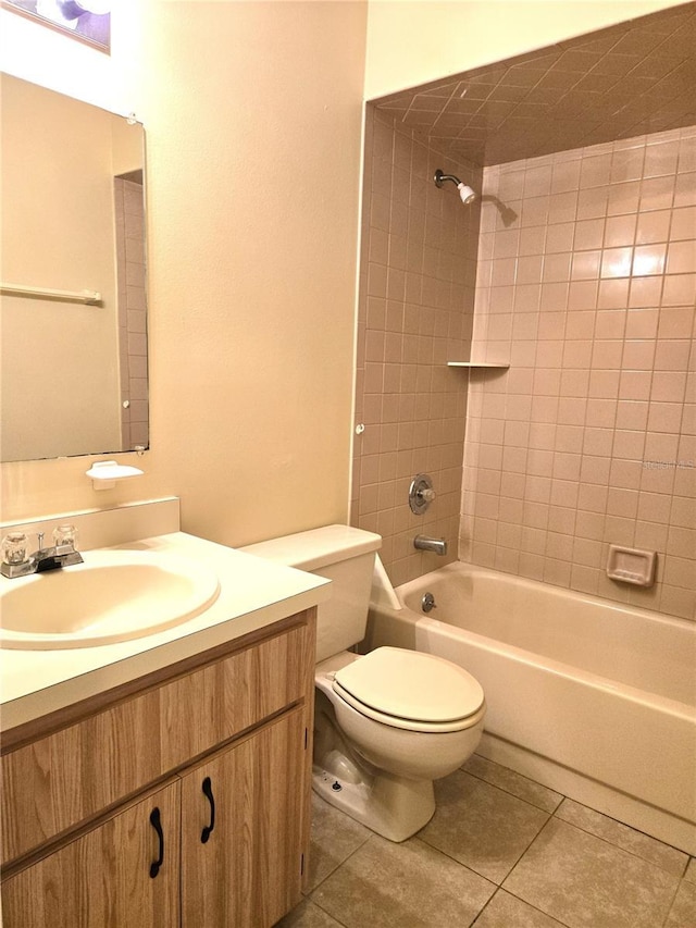 full bathroom featuring tile patterned flooring, tiled shower / bath combo, toilet, and vanity