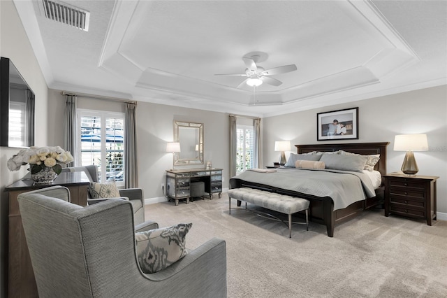 bedroom with light carpet, a raised ceiling, ceiling fan, and ornamental molding