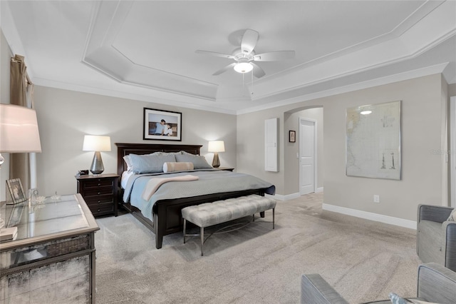 carpeted bedroom featuring a raised ceiling, ceiling fan, and ornamental molding