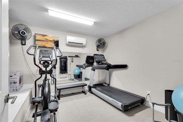 workout room featuring a wall mounted air conditioner and a textured ceiling