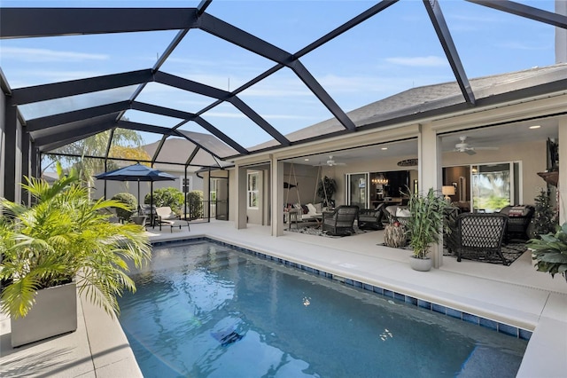 view of swimming pool with ceiling fan, an outdoor hangout area, a patio, and glass enclosure