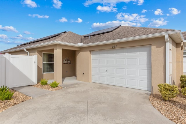 ranch-style home featuring solar panels and a garage