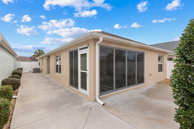 view of side of property featuring cooling unit and a patio area