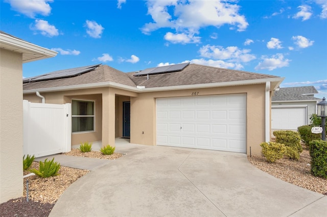 view of front of home featuring solar panels and a garage