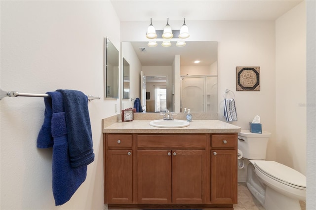 bathroom with vanity, a shower with shower door, and toilet