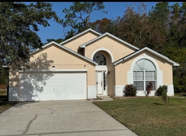 view of front of house with a garage and a front lawn