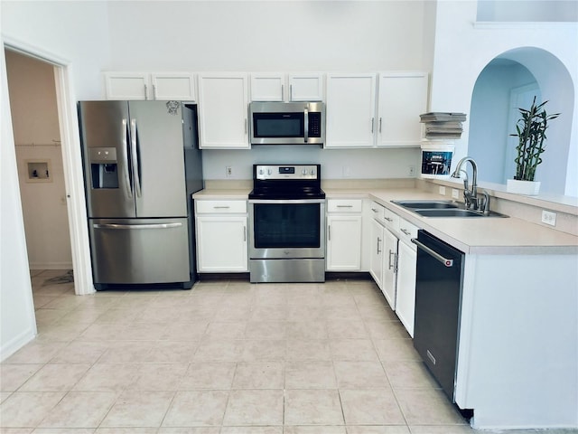 kitchen with white cabinetry, sink, kitchen peninsula, light tile patterned floors, and appliances with stainless steel finishes