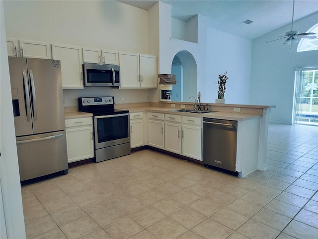 kitchen with white cabinets, kitchen peninsula, sink, and appliances with stainless steel finishes