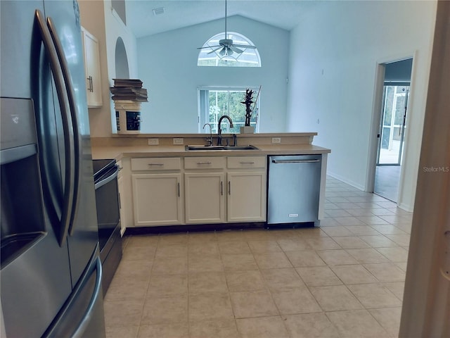 kitchen featuring kitchen peninsula, appliances with stainless steel finishes, ceiling fan, sink, and lofted ceiling