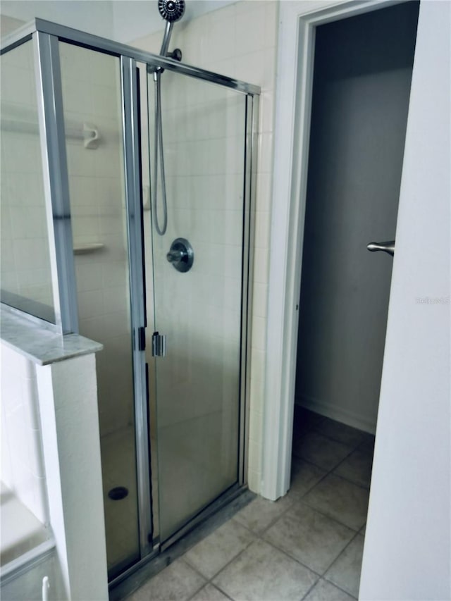 bathroom with tile patterned flooring and a shower with shower door