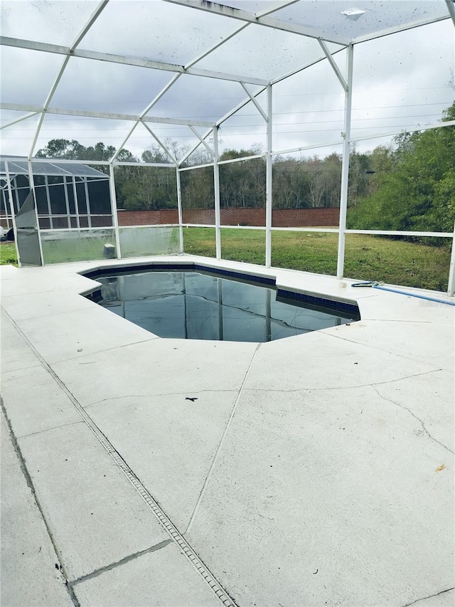 view of swimming pool with a lanai, a yard, and a patio