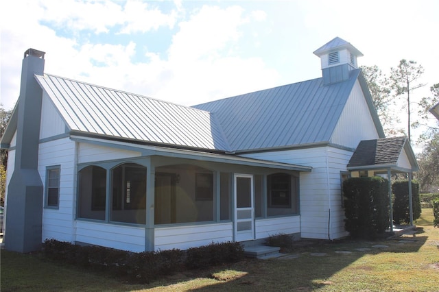 view of property exterior featuring a yard and a sunroom