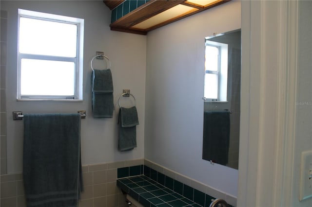 bathroom with plenty of natural light and tile walls