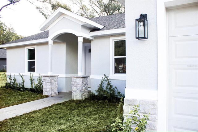 view of exterior entry with a lawn