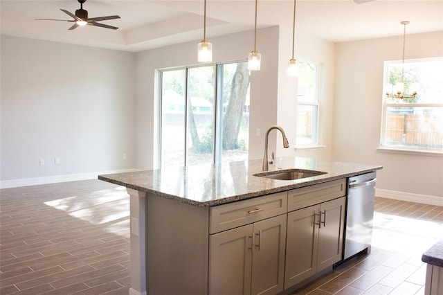 kitchen with stainless steel dishwasher, plenty of natural light, sink, and decorative light fixtures