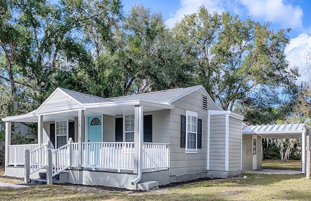 view of front of house featuring a carport, a porch, and a front yard