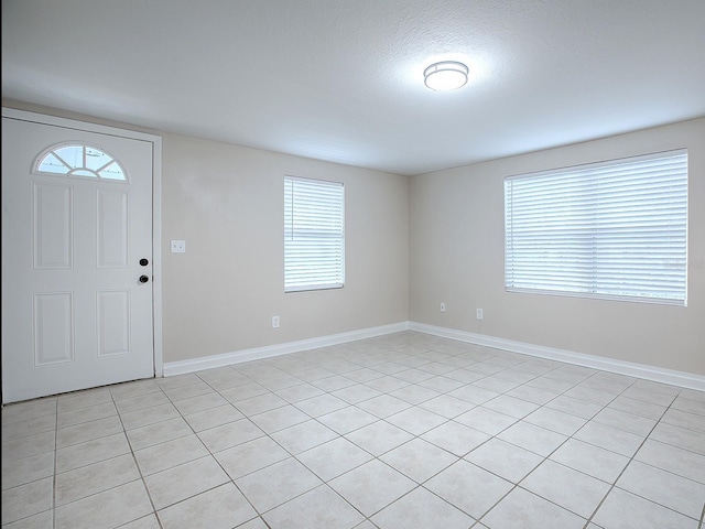 tiled foyer entrance with a textured ceiling