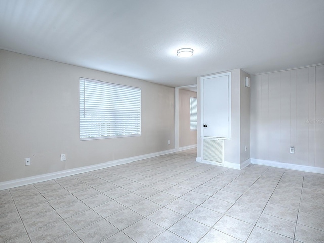 unfurnished room featuring light tile patterned floors and a textured ceiling