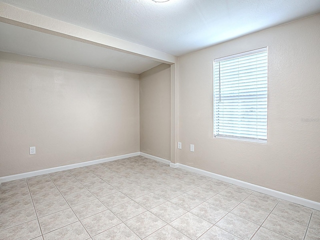 tiled spare room with a textured ceiling