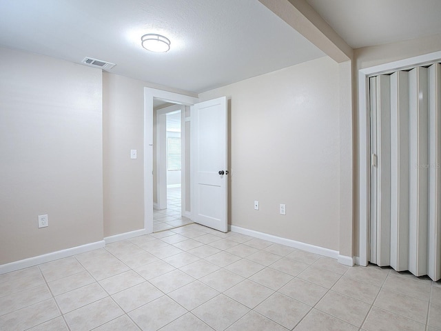 empty room with light tile patterned floors and a textured ceiling