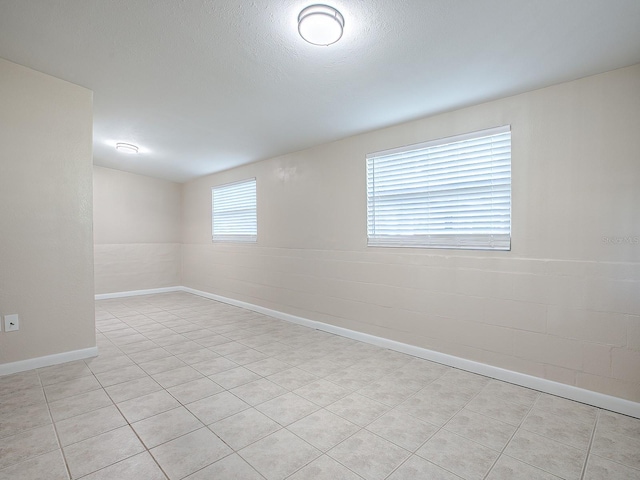 unfurnished room featuring light tile patterned floors and a textured ceiling