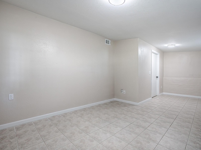 spare room with light tile patterned floors and a textured ceiling