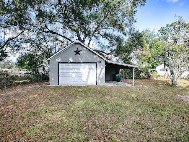 garage featuring a carport and a lawn