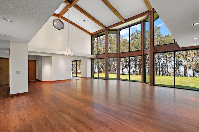 unfurnished living room with a textured ceiling, beam ceiling, wood-type flooring, an inviting chandelier, and high vaulted ceiling