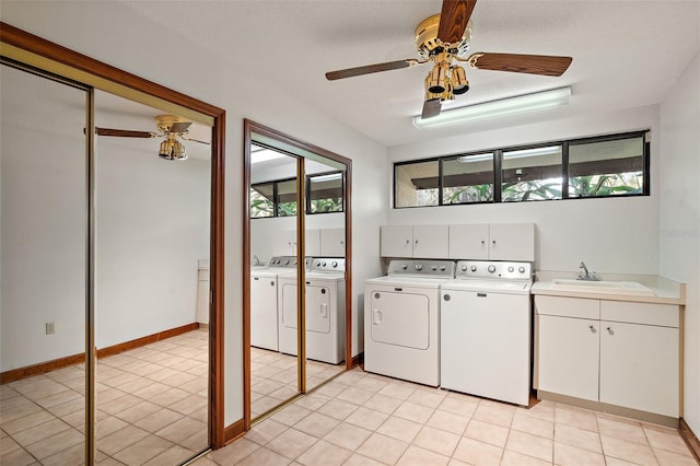 washroom featuring cabinets, ceiling fan, sink, light tile patterned floors, and washing machine and clothes dryer