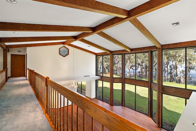 hall featuring carpet flooring and lofted ceiling with beams