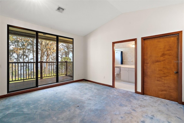 unfurnished bedroom featuring access to exterior, light colored carpet, ensuite bath, and lofted ceiling