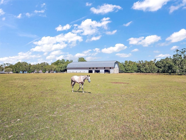 view of yard with a rural view and an outdoor structure