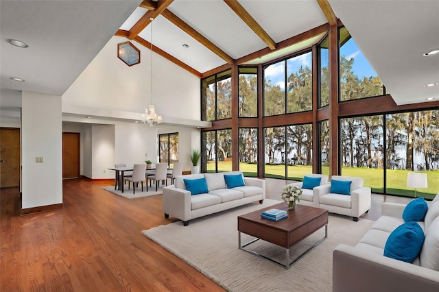 living room featuring beamed ceiling, wood-type flooring, an inviting chandelier, and high vaulted ceiling