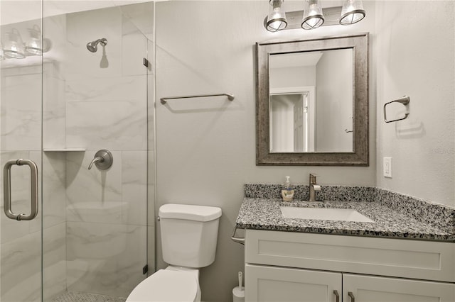 bathroom featuring vanity, toilet, and a shower with shower door