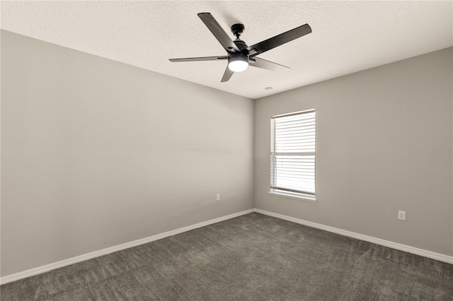 unfurnished room with a textured ceiling, dark carpet, and ceiling fan