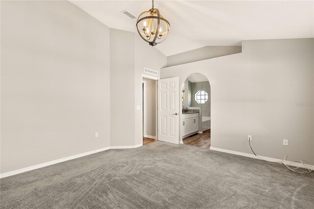 spare room with carpet, lofted ceiling, and a chandelier