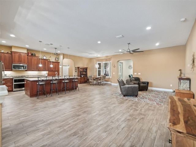 living room featuring ceiling fan and light wood-type flooring