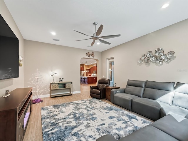 living room featuring ceiling fan and light hardwood / wood-style flooring