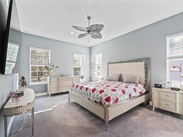 carpeted bedroom featuring ceiling fan and multiple windows