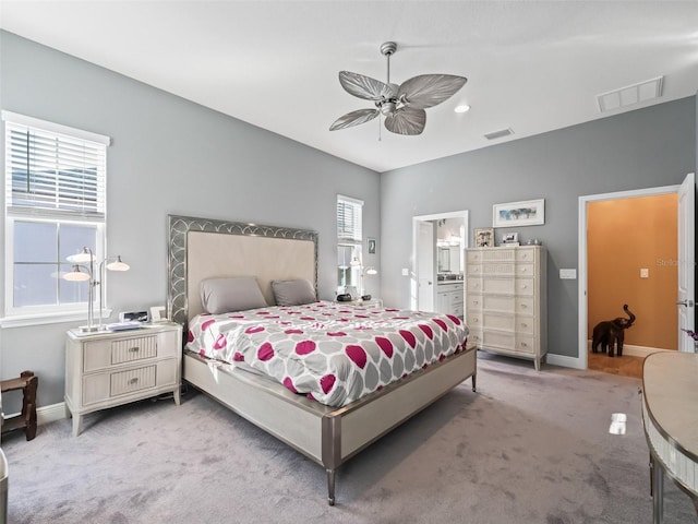 carpeted bedroom featuring ceiling fan and ensuite bathroom