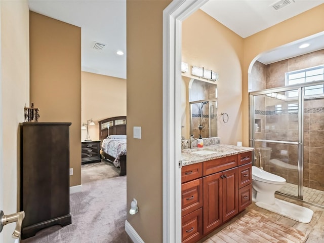 bathroom with walk in shower, vanity, and toilet